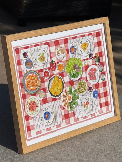A framed print featuring a colorful table set featuring various Vietnamese ultural dishes.